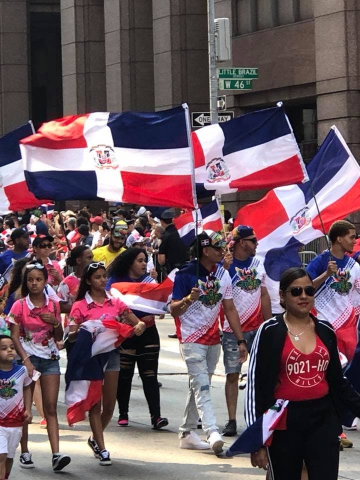 Entre la multitud de gente emocionada, los únicos colores que se ven son los colores de la bandera roja, blanca y azul, que los dominicanos llevan con orgullo.
