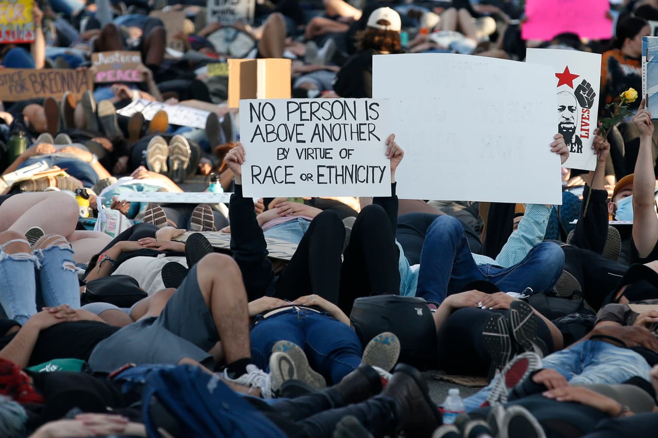 "Ninguna persona está por encima de otra por atribución de raza o etnia", se lee en uno de los carteles durante masiva protesta silenciosa frente al capitolio de California, en la ciudad de Sacramento.