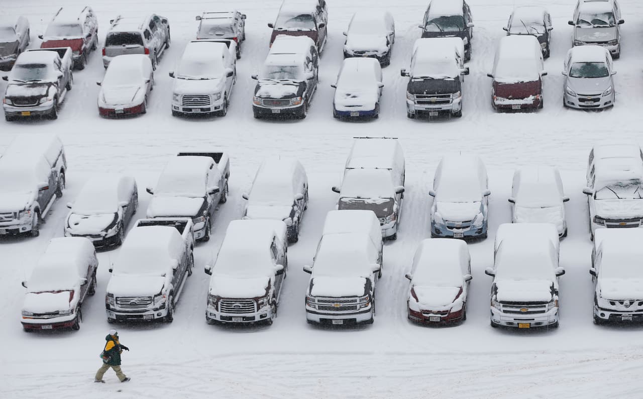 Un hombre camina sobre la nieve en el campo de Lambeau antes de un juego de fútbol de NFL entre los Green Bay Packers y los Seahawks de Seattle.