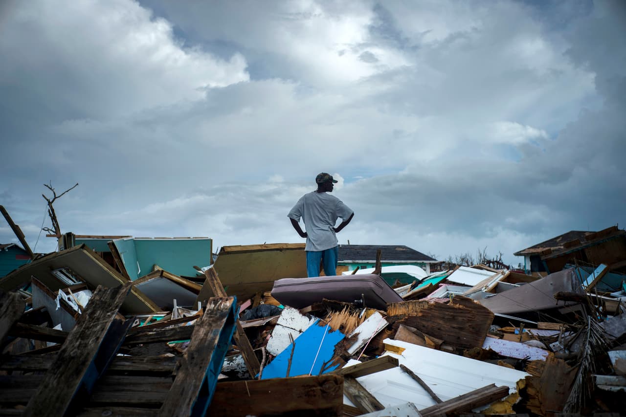 Un hombre se para sobre los escombros de su casa en un barrio haitiano, después del paso del huracán Dorian en Ábaco, Bahamas, el 16 de septiembre de 2019.