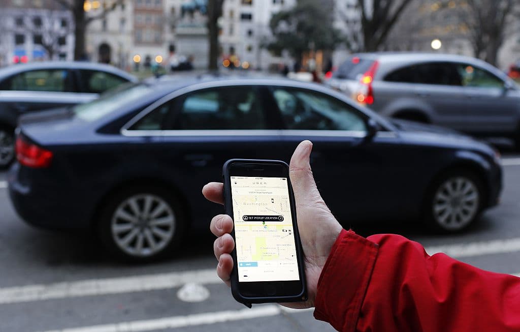 An UBER application is shown as cars drive by in Washington, DC on March 25, 2015. Uber said it was ramping up safety in response to rape allegations against a driver in India and growing concerns about background checks for operators of the popular ride-sharing service. In other cities where Uber operates, critics had complained that a lack of licensing and background checks of drivers could imperil those who use the service. AFP PHOTO/ ANDREW CABALLERO-REYNOLDS (Photo credit should read Andrew Caballero-Reynolds/AFP/Getty Images)