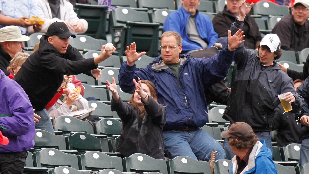 Un aficionado atrapa la pelota bateada por Chris Young, de los Diamondbacks de Arizona, en el partido contra los Rockies de Colorado el martes 24 de mayo de 2011. Los Rockies ganaron 12-4.