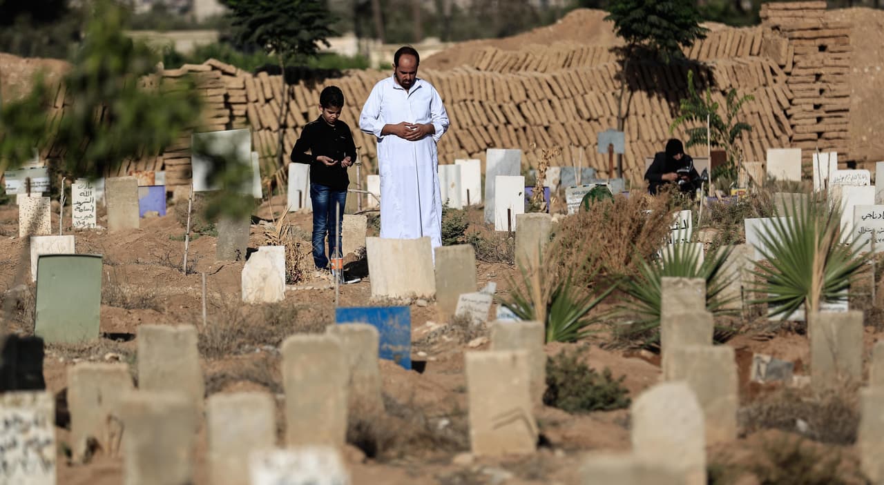Un padre y su hijo recorren el cementerio de Douma, al este de Damasco.