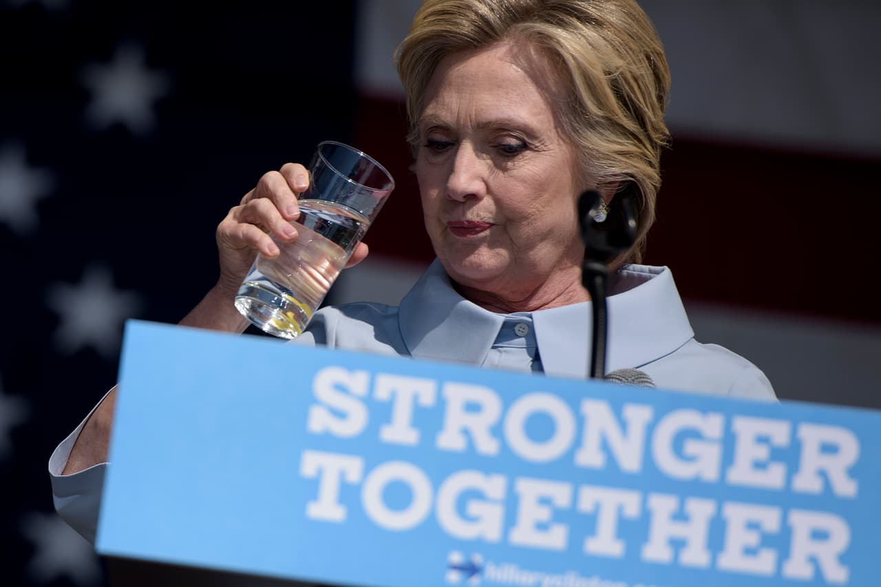 La candidata demócrata Hillary Clinton toma un sorbo de agua para calmar su ataque de tos durante un rally en el Día del Trabajo en Cleveland, Ohio, el 5 de septiembre de 2016.