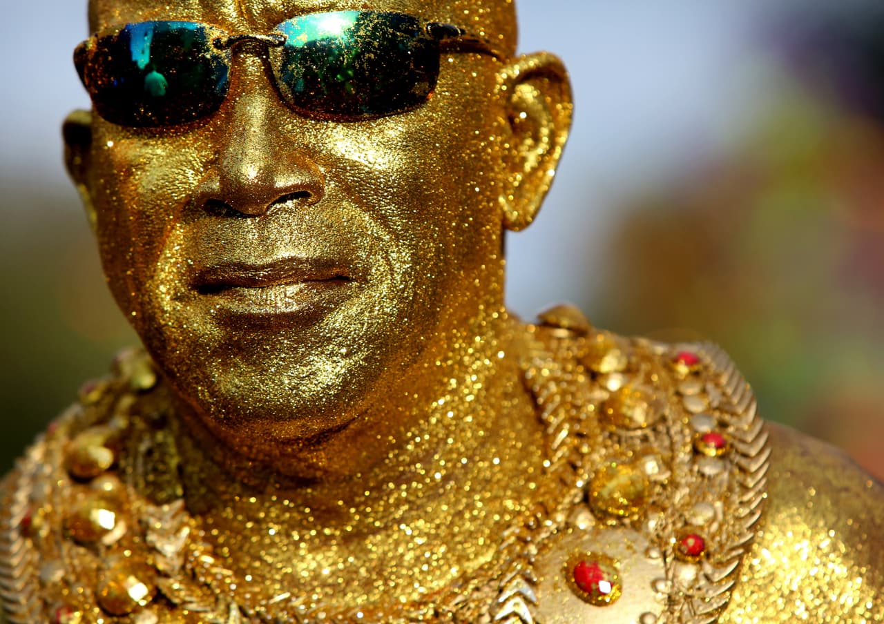 Un hombre cubierto de oro brilla a pesar de los cielos grises que marcaron las festividades.