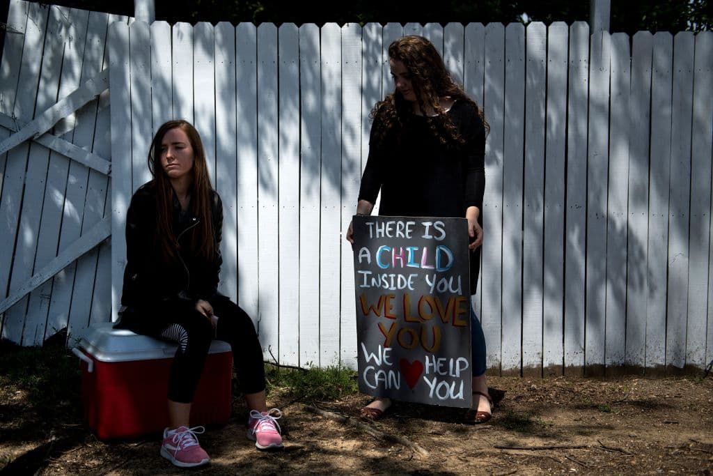 "Hay un niño dentro de ti, te amamos, podemos ayudarte", reza el cartel que sostienen estas jóvenes en la última clínica que ofrece abortos en Mississippi.