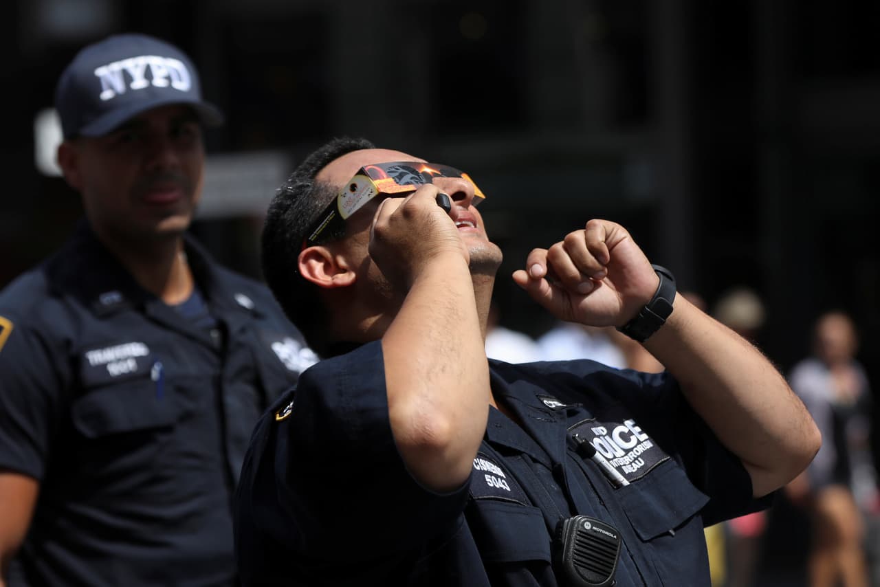 Incluso los policías que resguardan Times Square se pusieron sus gafas protectoras para ver el eclipse solar. (Shannon Stapleton/Reuters)