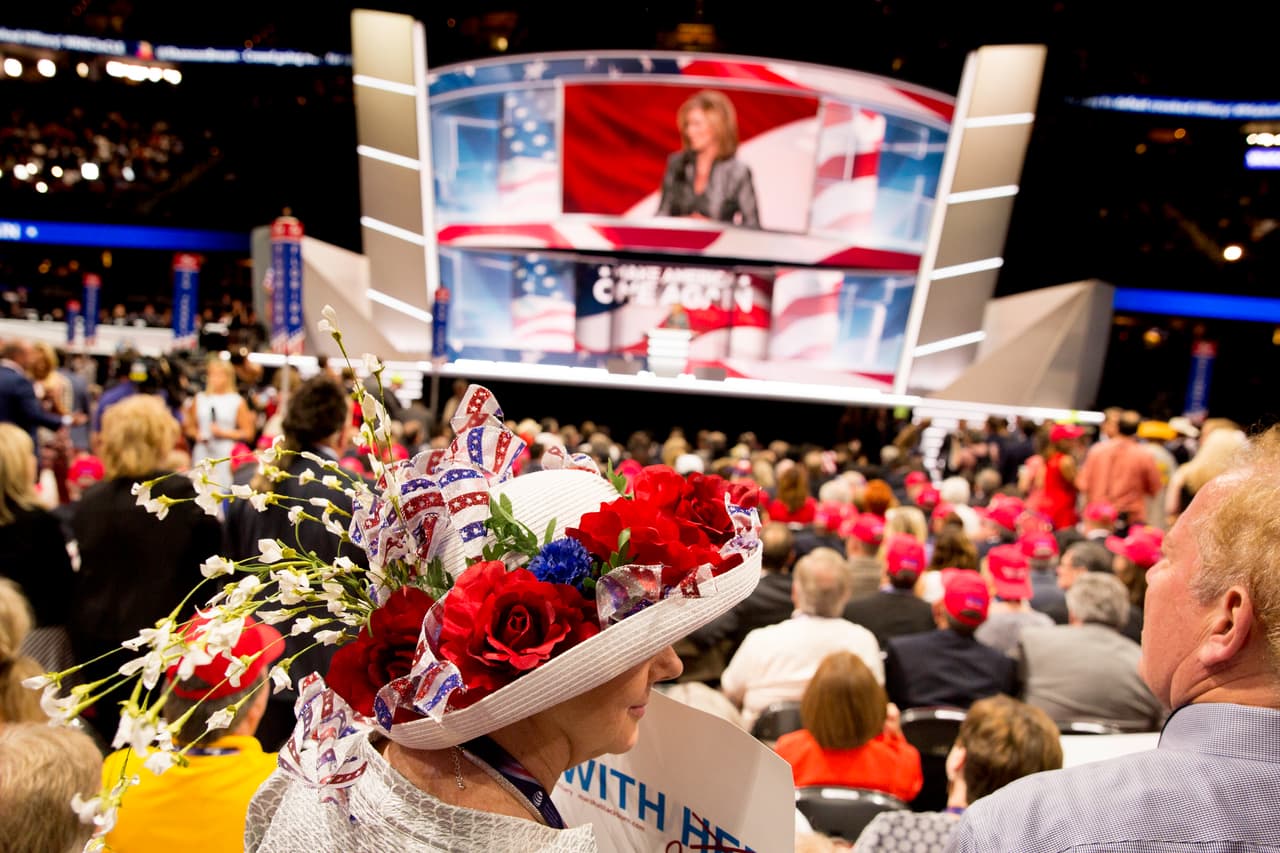 Una delegada lleva este curioso sombrero mientras espera de pie las presentaciones estelares de la noche.