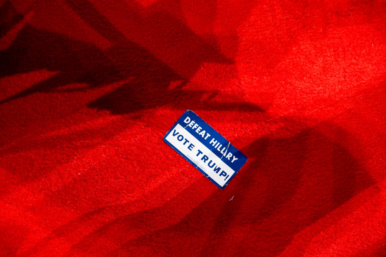 Una etiqueta que dice “vence a Hillary, vota por Trump”, se ve pegada de la ropa de muchos de los asistentes, o en el suelo.