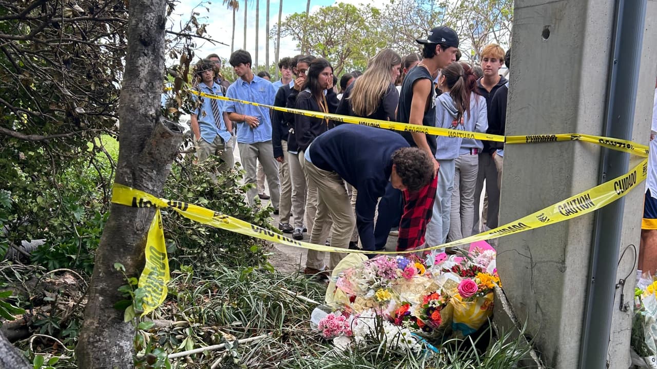 Decenas de estudiantes, amigos y familiares de Alessia Tucci, de 16 años, y Mateo Dávila, de 17, la joven pareja que murió tras el choque del carro en Doral, se acercan a dejar flores en el sitio de la tragedia.
