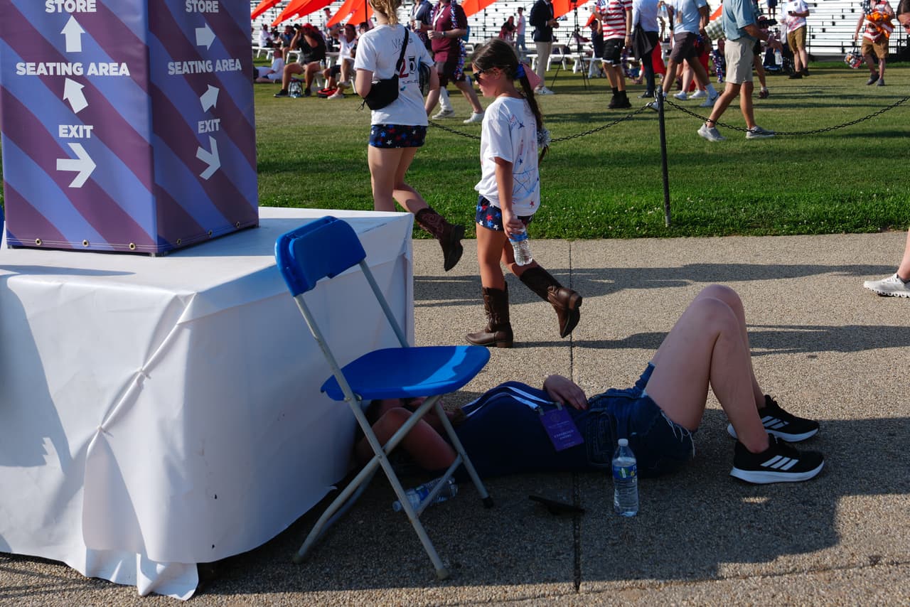 Una persona descansa a la sombra mientras la gente llega al evento "Homenaje a Estados Unidos" para conmemorar el 250 aniversario de la independencia del país, el sábado 4 de julio de 2026, en el National Mall de Washington.