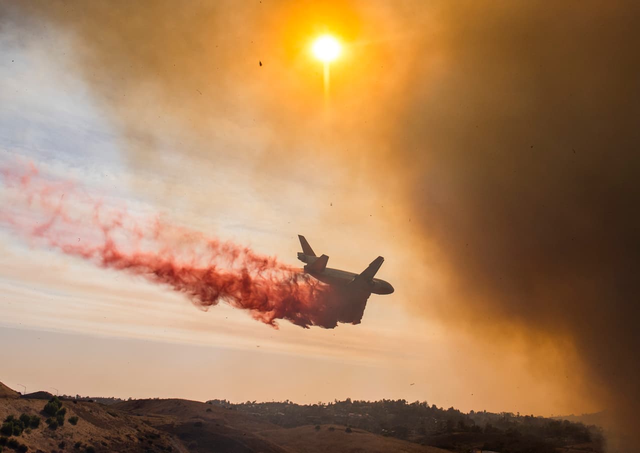 Un avión descarga una sustancia para sofocar el fuego en Anaheim Hills, un incendio desatado en el sur de California y que 
<b><a href="http://www.univision.com/los-angeles/kmex/noticias/incendios/incendio-en-anaheim-hills-arrasa-8-000-acres-y-destruye-multiples-viviendas">ha consumido 8,000 acres.</a></b> El fuego más grande está en el condado de Sonoma, al norte del estado, donde se reportan el mayor número de fallecimientos y al menos 500 personas como desaparecidas.