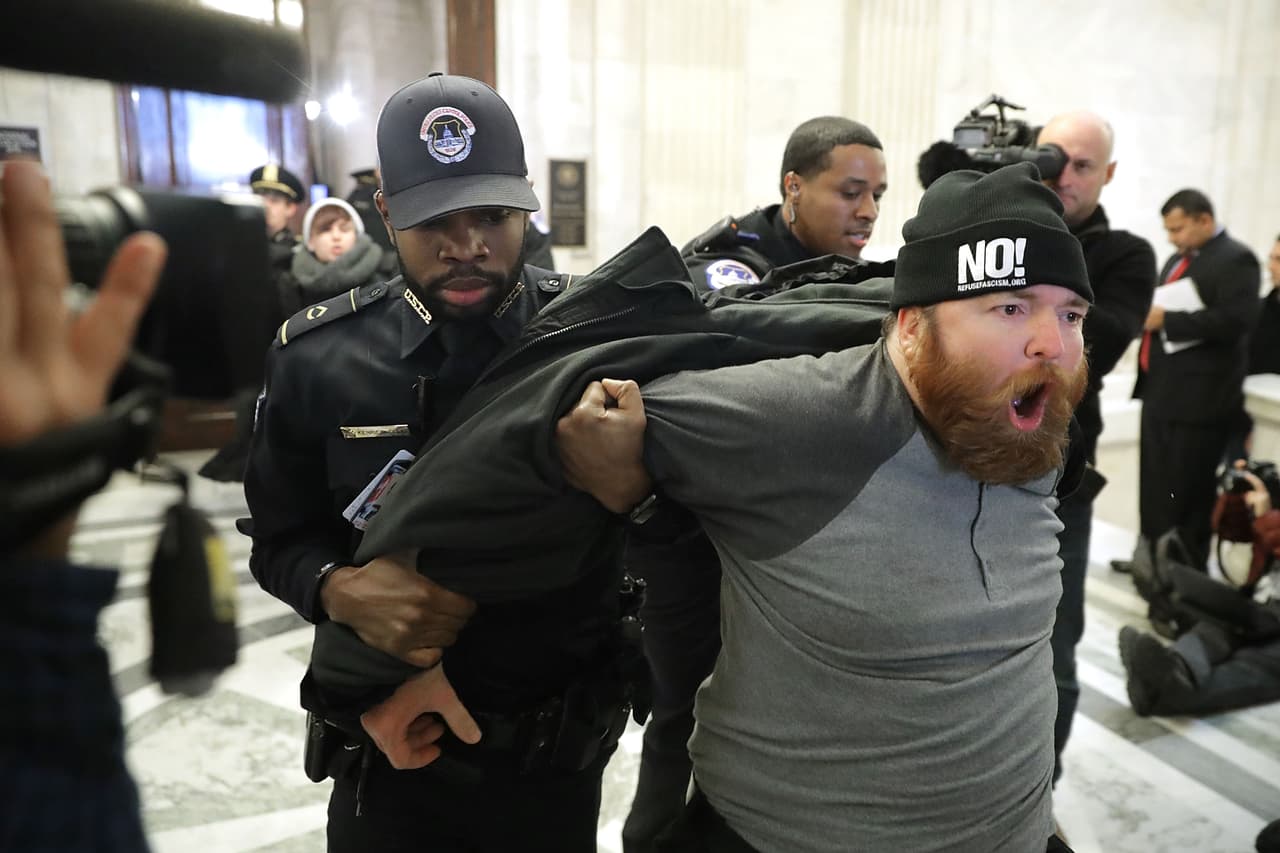 <b>Contra Jeff Sessions (10 de enero).</b> Faltando una semana para el comienzo del nuevo gobierno el clima de protestas comenzaba a subir en Washington. La audiencia de confirmación del
<b><a href="https://www.univision.com/noticias/politica/los-elegidos-de-trump-asi-funciona-el-proceso-de-confirmacion-del-gabinete-en-el-senado">nuevo fiscal General, Jeff Sessions</a></b>, llevó a algunos manifestantes a protestar dentro del senado. “No KKK, no Trump, no EEUU facista…”, gritaba este manifestante dentro del capitolio cuando fue arrestado.