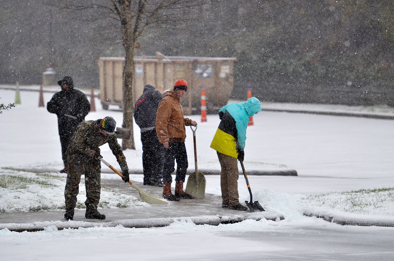 El Servicio Meteorológico Nacional dijo que Winston-Salem, Greensboro, Roxboro y otras ciudades de Carolina del Norte, habían recibido 15 centímetros (seis pulgadas) o más de nieve durante la noche. En la imagen se observa a un grupo de trabajadores limpiar aceras en Charlotte. La recomendación de las autoridades: intentar permanecer bajo resguardo.