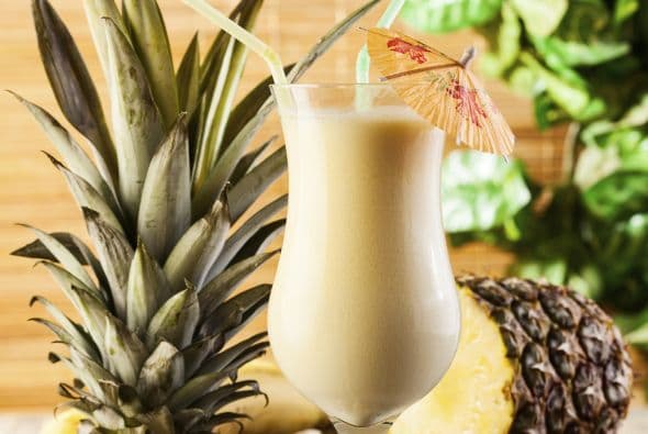 Añade 1 cucharada de extracto de coco y 2 cucharadas de azúcar. Coloca dos cubos de hielo en una copa, y vierte tu ‘drink’ sobre ellos. Decóralo con hojas de menta.