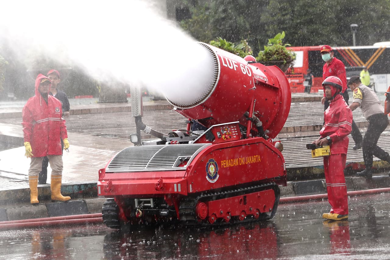 <b>Desinfección a chorros en todo el mundo (22 de marzo). </b>Bomberos rocían masivamente líquido para matar el coronavirus en Yakarta, Indonesia, el domingo. En un esfuerzo global por contener la propagación el coronavirus, los espacios públicos y medios de transporte en decenas de países fueron limpiados con soluciones desinfectantes.
