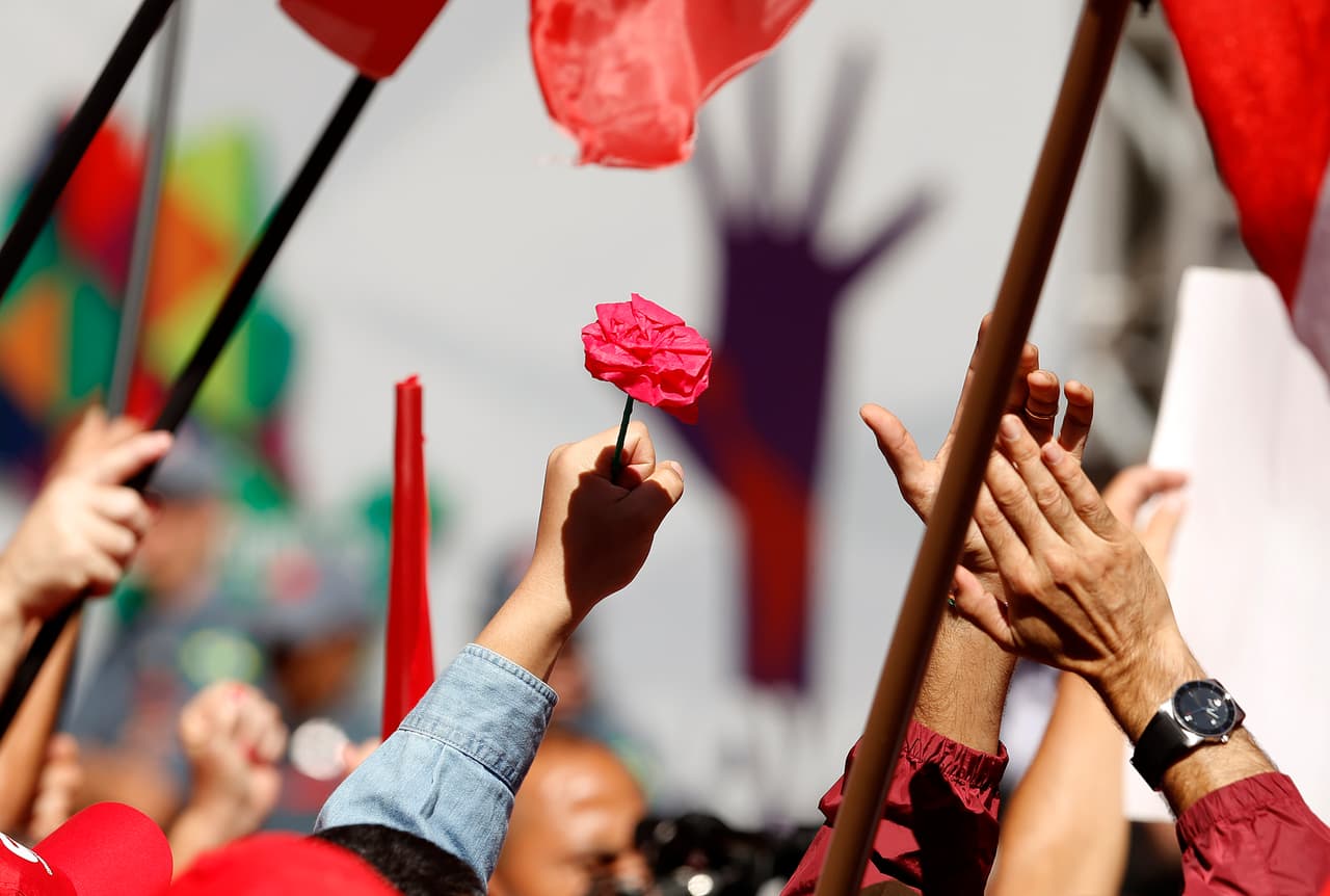 Un manifestante sostiene una flor roja durante una manifestación del Primero de Mayo en apoyo a la presidenta de Brasil, Dilma Rousseff.