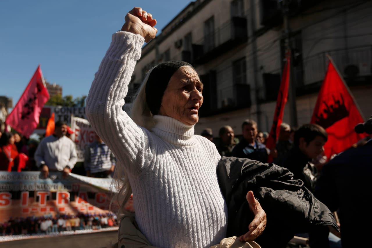Irma Domínguez canta y mantiene su puño en alto durante una marcha para celebrar el Primero de Mayo, en Asunción, Paraguay.