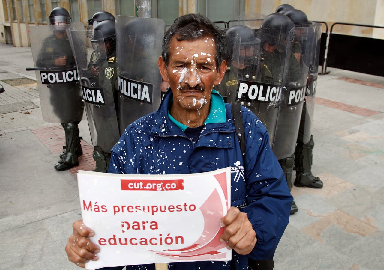 Un trabajador sostiene un cartel que dice "Más Presupuesto para Educación" en Bogotá, Colombia.