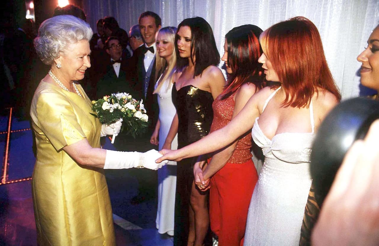 <b>Spice Girls</b>
<br>
<br>En 1997, las integrantes de la agrupación británica Spice Girls tuvieron el privilegio de estar frente a frente con la Reina Isabel ll. El encuentro se dio en el Teatro Victoria Palace donde la sobriedad y la elegancia de la monarca mostraba la importancia del evento. Por otro lado, las intérpretes de ‘Wannabe’ lucieron unos brillantes vestidos escotados fieles a su estilo y además rompiendo con los estereotipos de atuendo.
