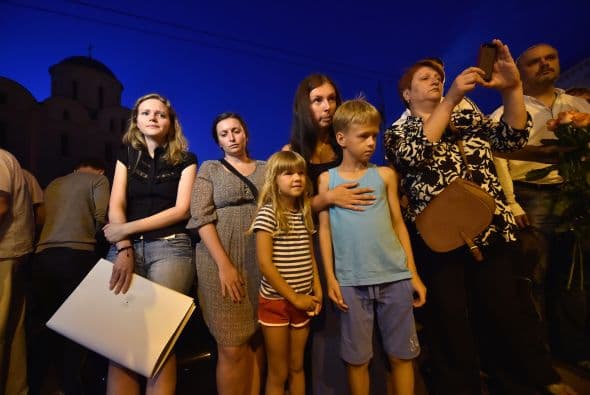 Personas dejan ramos de flores en conmemoración de las víctimas del avión estrellado de Malaysia Airlines al este de Ucrania frente de la embajada de Holanda en Kiev.