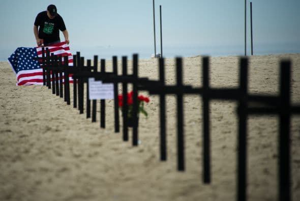 Los manifestantes, de la ONG Río de Paz, también instalaron en la playa una bandera estadounidense y un cartel de seis metros de largo y tres de alto con el dibujo de una paloma herida, manchada por manos sucias de sangre.
