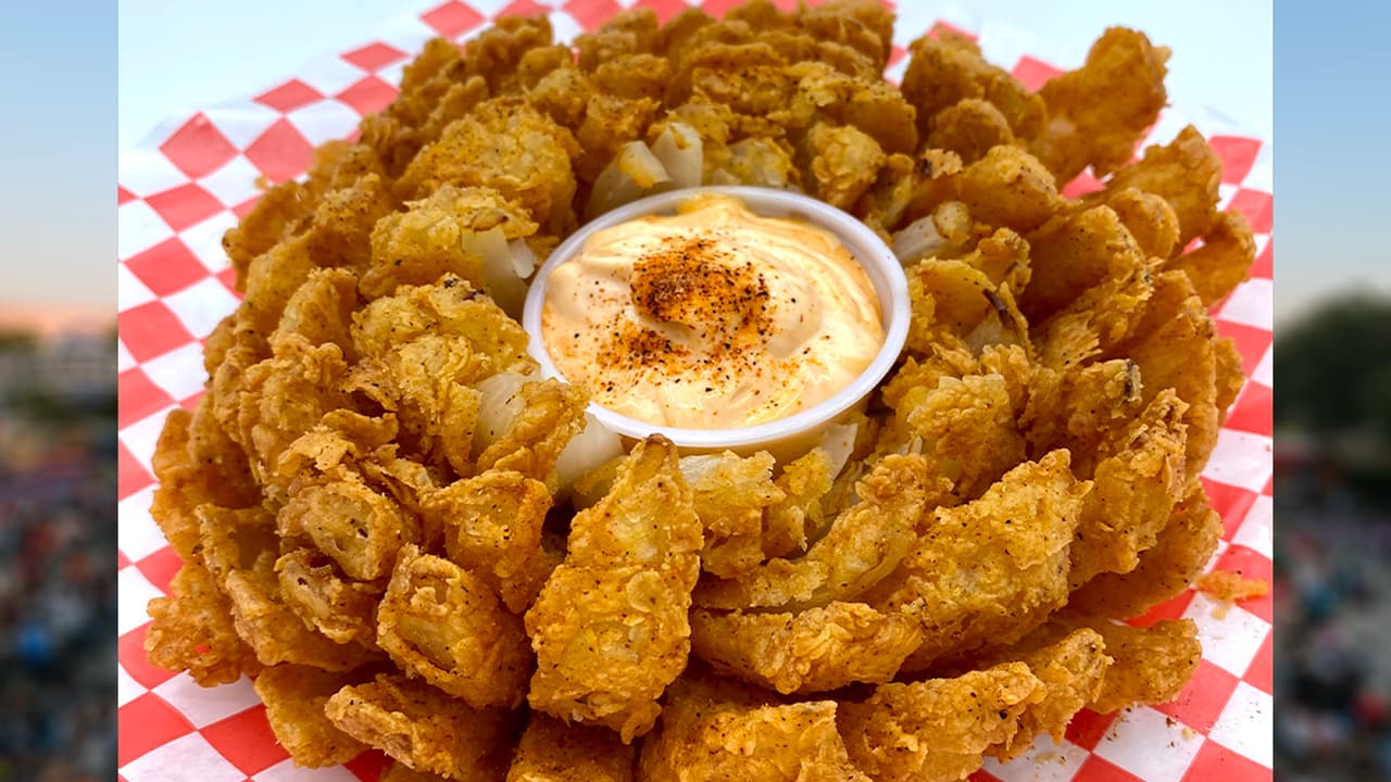 <b>BLOOMING ONION </b>de Cajun Cowboy
<br>Una “colosal” cebolla frita
<b>acompañada con condimentos cajún </b>y una deliciosa salsa.