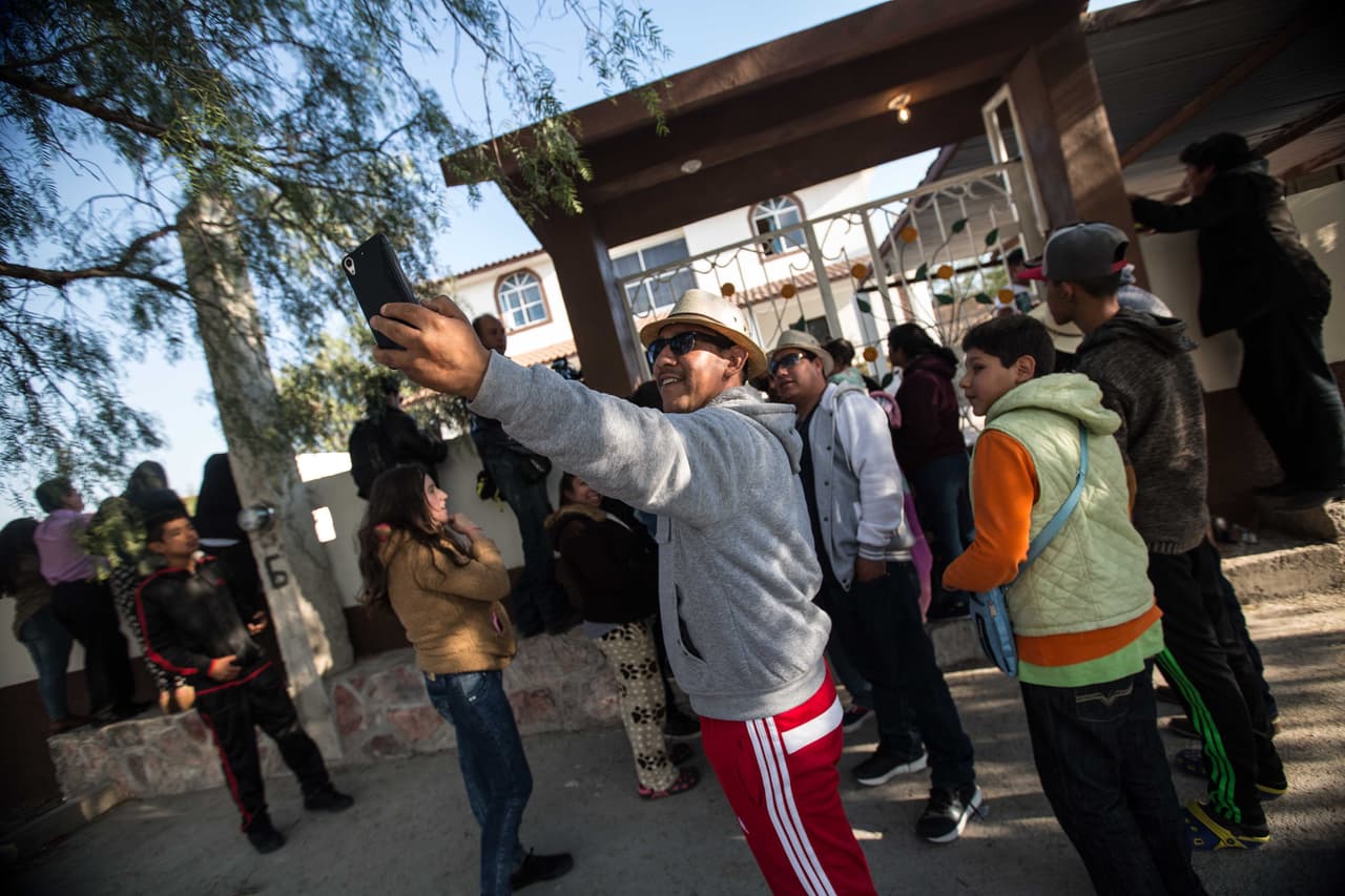 Un grupo de visitantes se toma un fotografía con su celular enfrente de la casa de Rubí Ibarra, para que quede constancia de que acudieron a la fiesta.