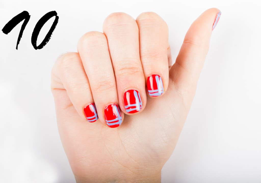Aplica 2 capas de esmalte rojo. Con un pincel delgado traza 2 líneas verticales y 2 horizontales con un tono azul. Deja secar y sella con una capa de brillo. Nail art: Gabriela Guerrero y María Sofía Pérez. Esmaltes: Jessica Nails.