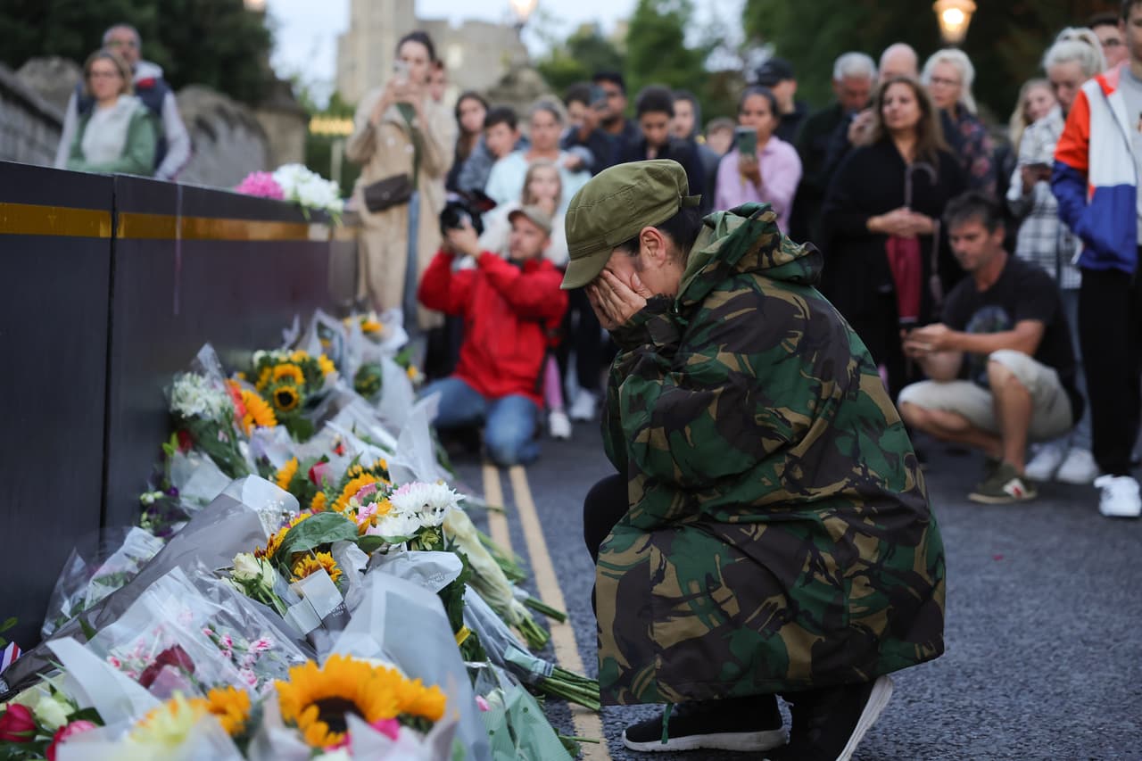 Una mujer llora a la reina en las afueras del castillo de Windsor, que se llenó de flores de todos colores dejadas por decenas de personas para honrar a la monarca.