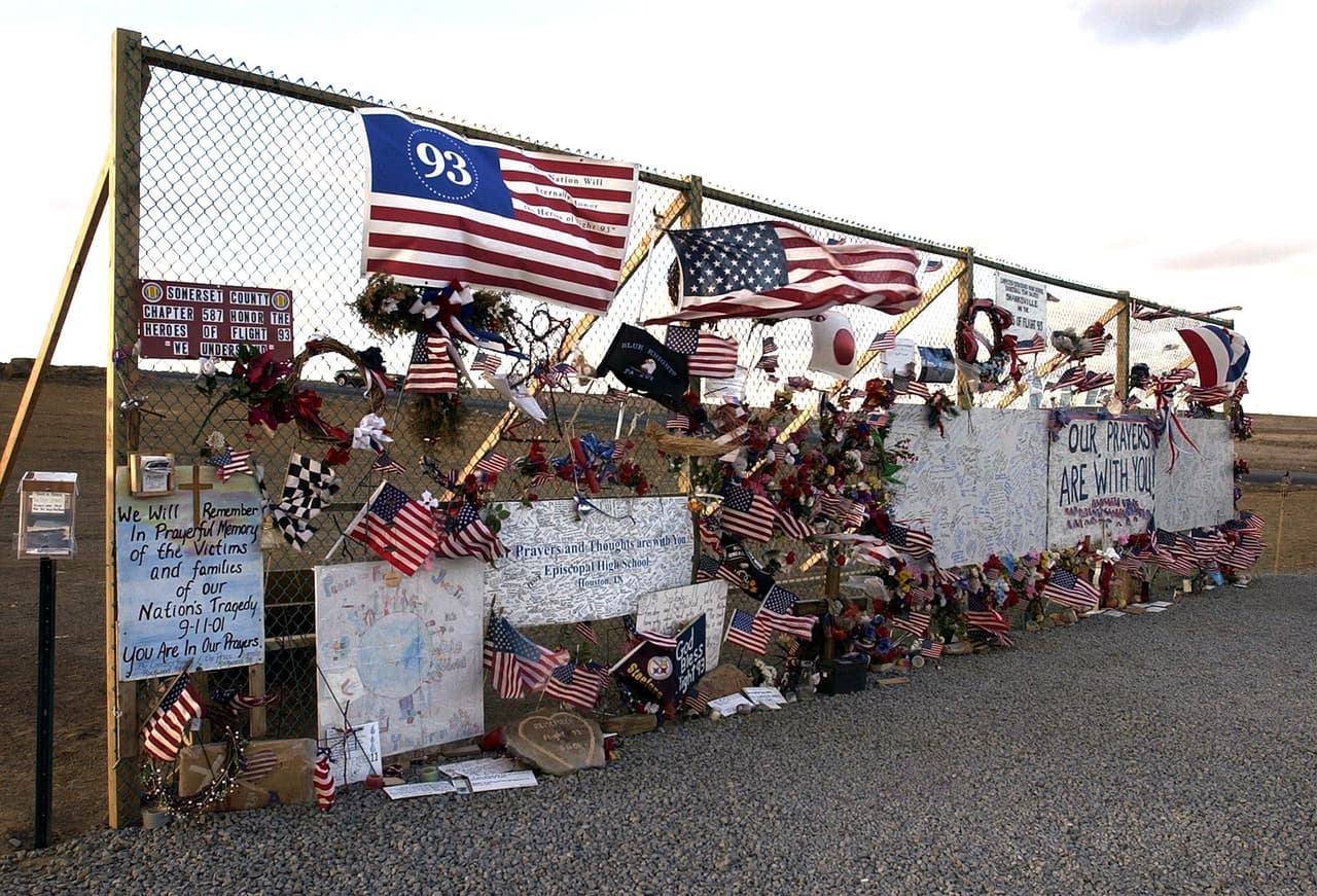 Después de una breve discusión los pasajeros decidieron luchar contra los secuestradores.
<br>
<br>"Sé que todos vamos a morir, somos tres los que vamos a hacer algo al respecto, te amo cariño", le dijo el pasajero Thomas Burnett Jr a su esposa por teléfono. La asistente de vuelo Sandy Bradshaw llamó a su esposo y le explicó que estaba llenando jarras con agua hirviendo. “Todos corren a primera clase, tengo que ir, adiós”, fue lo último que le dijo.
<br>
<br>En la fotografía un monumento improvisado erigido en el lugar seis meses después de la tragedia.
<br>