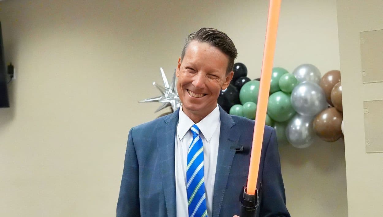 Tom Bexley, secretario de la corte y contralor del condado de Flagler, sostiene su sable de luz antes de oficiar una ceremonia grupal de bodas temática de
<i>Star Wars</i>para varias parejas el 4 de mayo de 2026, en el Kim C. Hammond Justice Center en Bunnell.