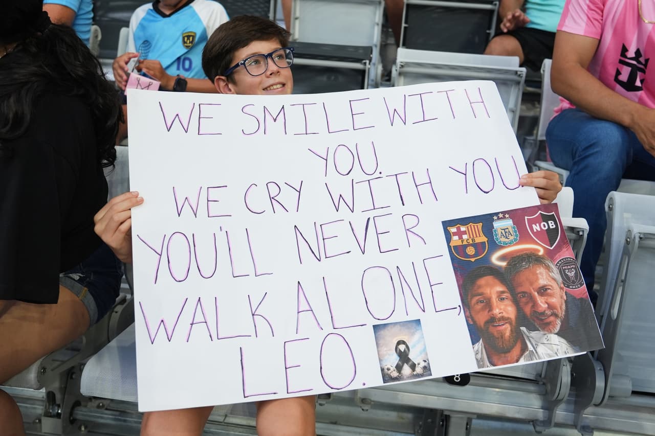 Un aficionado sostiene un cartel en memoria de Jorge Messi, padre del delantero del Inter Miami, Lionel Messi, quien falleció durante la primera mitad de un partido de la Leagues Cup, el sábado 8 de agosto de 2026, en Miami. (Foto AP/Lynne Sladky)