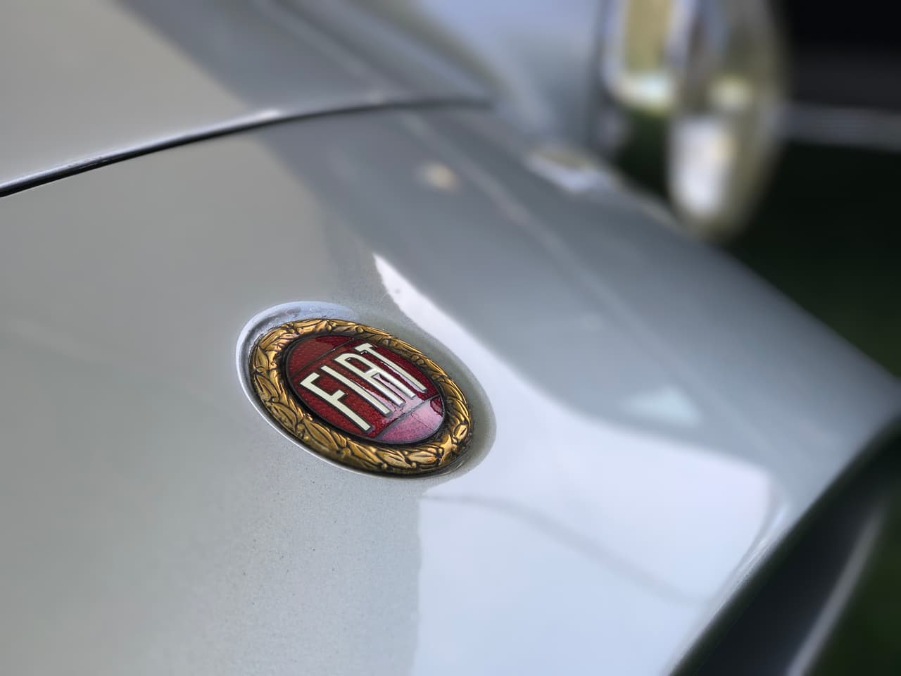 El medallón logotipo en el borde exterior del
<b>Fiat-Stanguellini 1200 Spider America de 1957</b> diseñado por Bertone es prácticamente idéntico a los que utilizan los modelos Fiat de hoy en día.