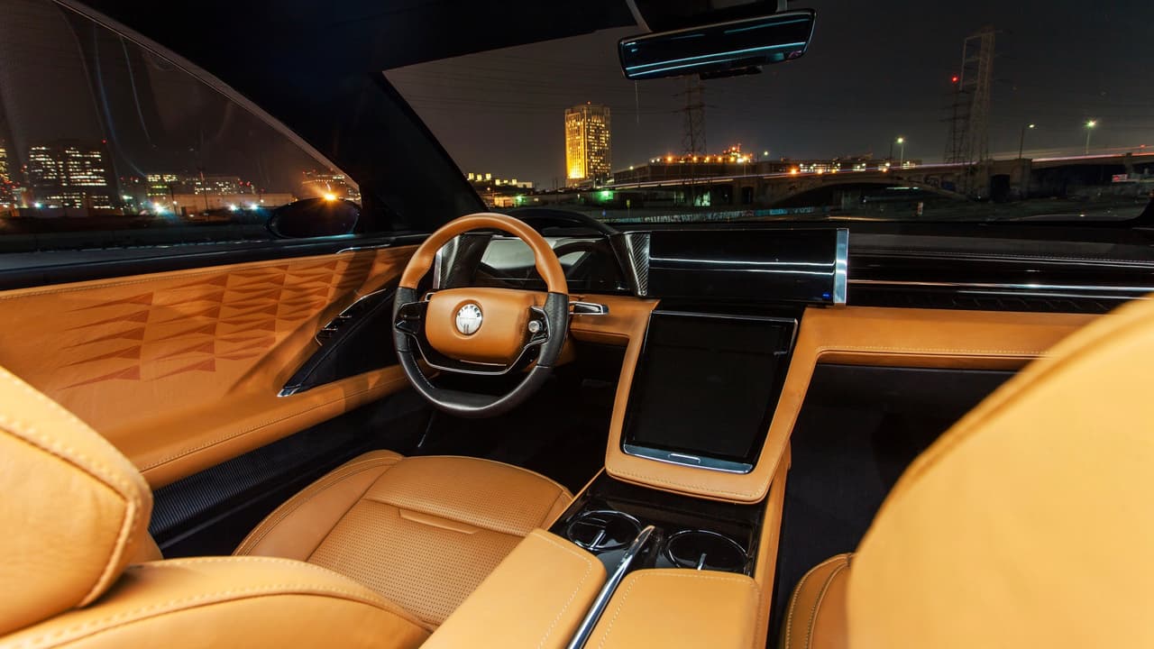 El lujo abunda en el suntuoso interior del Fisker EMotion donde existen 
<b>extensas superficies cubiertas en cuero</b> pero donde también se ven amplios elementos estructurales con fibra de carbono expuestas. Para los que no son amantes del cuero no hay problema, el Fisker EMotion también ofrecera un 
<b>interior 'vegan'</b>, libre de productos animales.