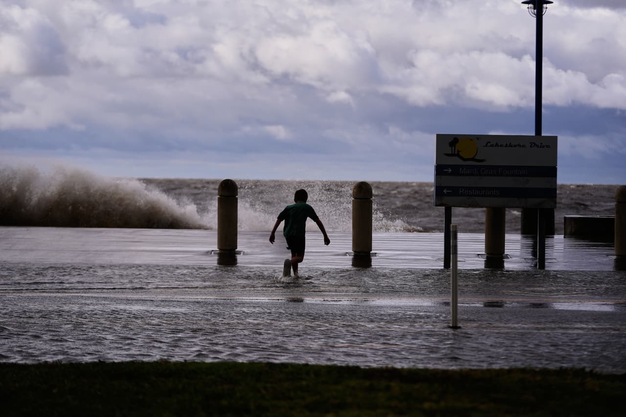 Josiah Carpenter, de 8 años, juega alegremente entre las aguas de la crecida en Lakeshore Drive, junto al lago Pontchartrain, mientras la tormenta tropical Bertha se acerca a la costa de Luisiana el miércoles 22 de julio de 2026, en Nueva Orleans. (Foto AP/Gerald Herbert)