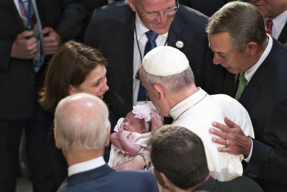 Ante Joe Biden y John Boehner, Francisco bendice a un pequeño en el Salón de las Estatuas en el Capitolio.
