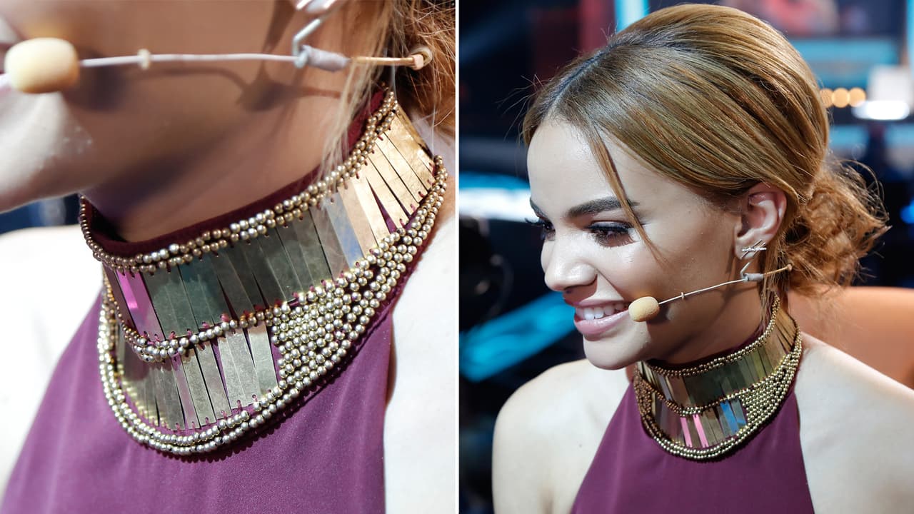 Este collar dorado es bastante particular y resalta su cara delgada junto al peinado con el pelo recogido.