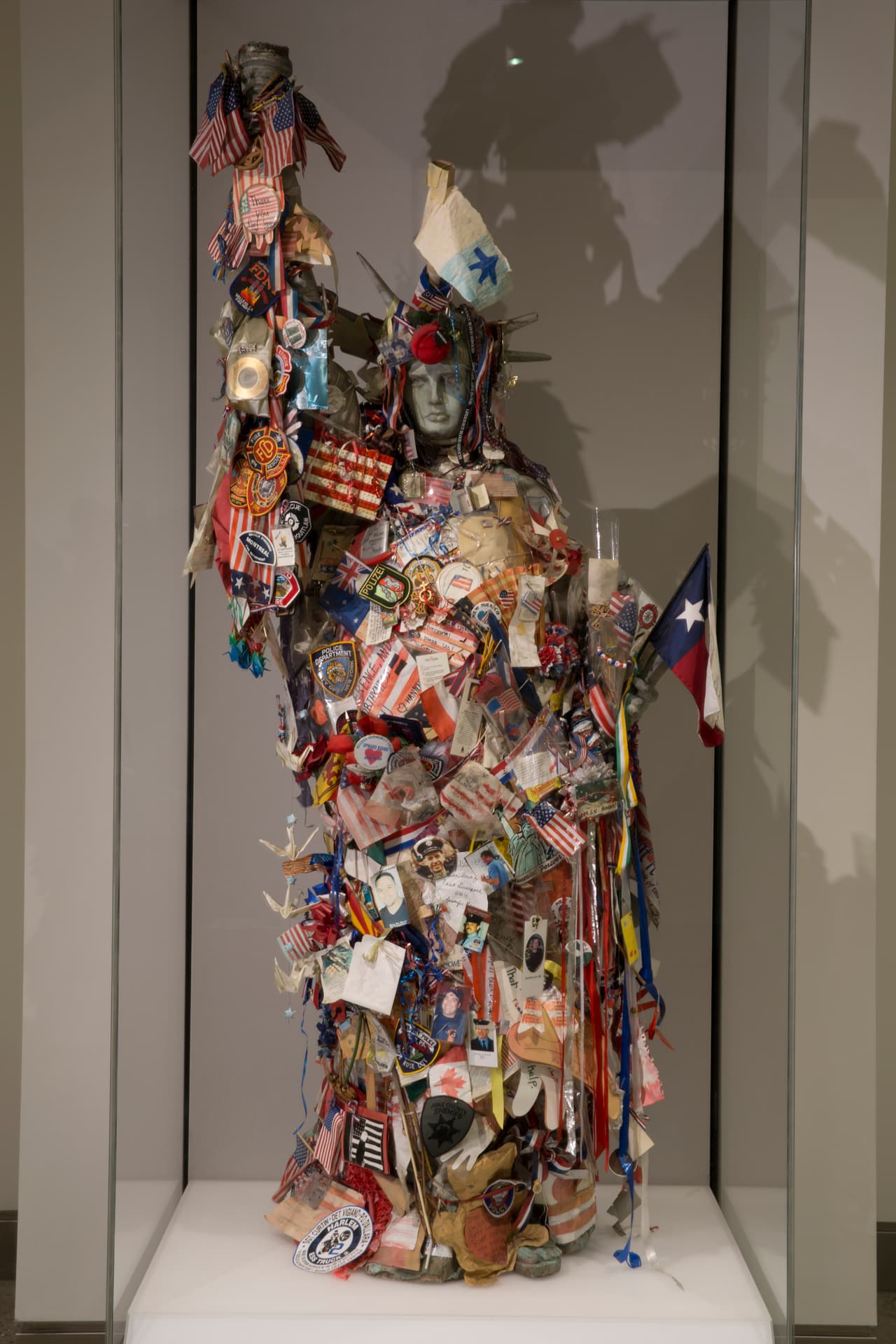 Poco después del 11 de septiembre, esta réplica en fibra de vidrio de la Estatua de la Libertad apareció en la acera frente a una estación de bomberos de Manhattan y allí se fue llenando de detalles conmemorativos. Hoy está expuesta en el
<a href="https://www.911memorial.org/"><u>Museo y Monumento Nacional del 11 de septiembre</u></a>.