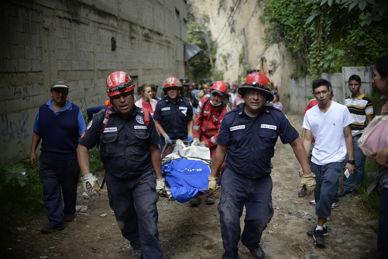 El desastre ocurrido en Santa Catarina Pinula, en Guatemala, el 2 de octubre de 2015 dejó un total de 280 muertos y 70 desaparecidos. Rescatistas cargan una de los centenares de víctimas.