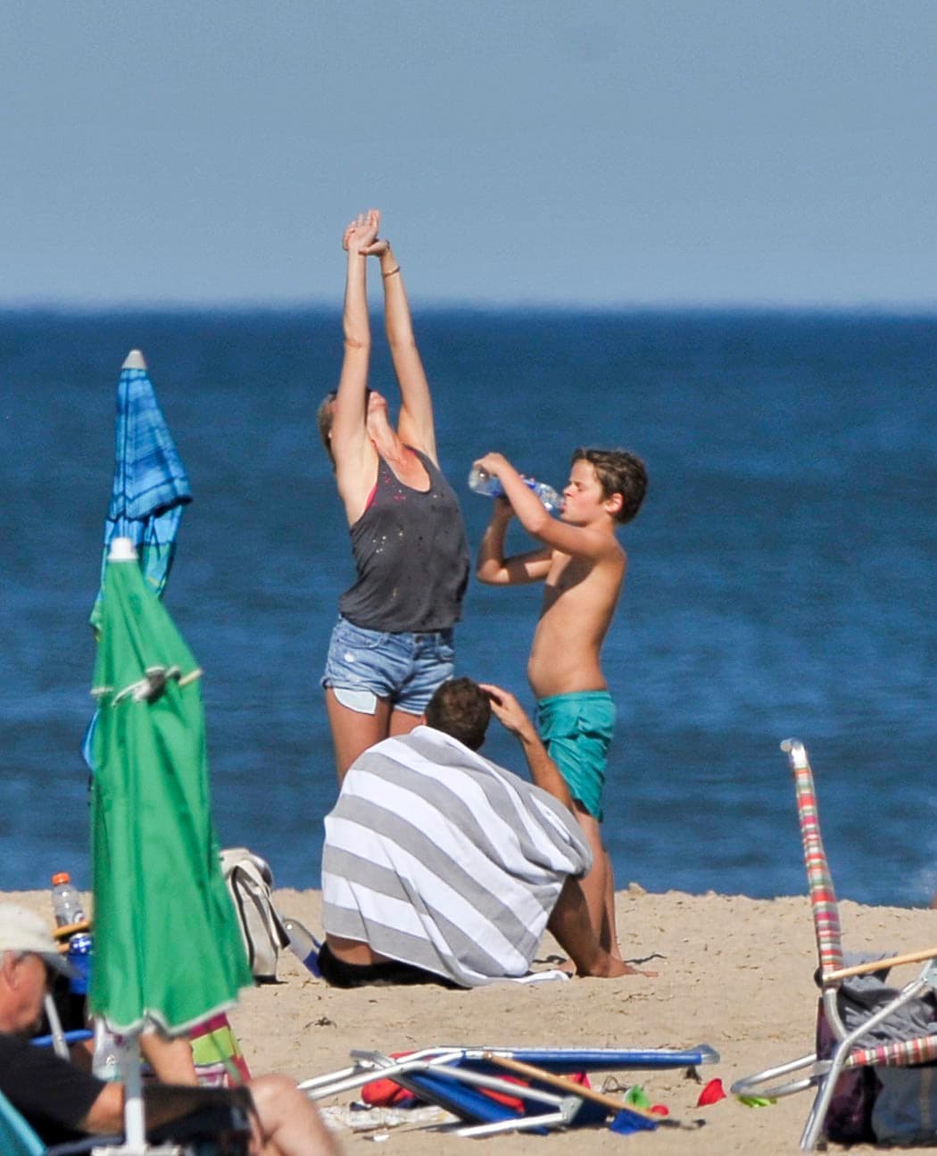 Mientras ella se estiraba, él se sentó y se secaba.