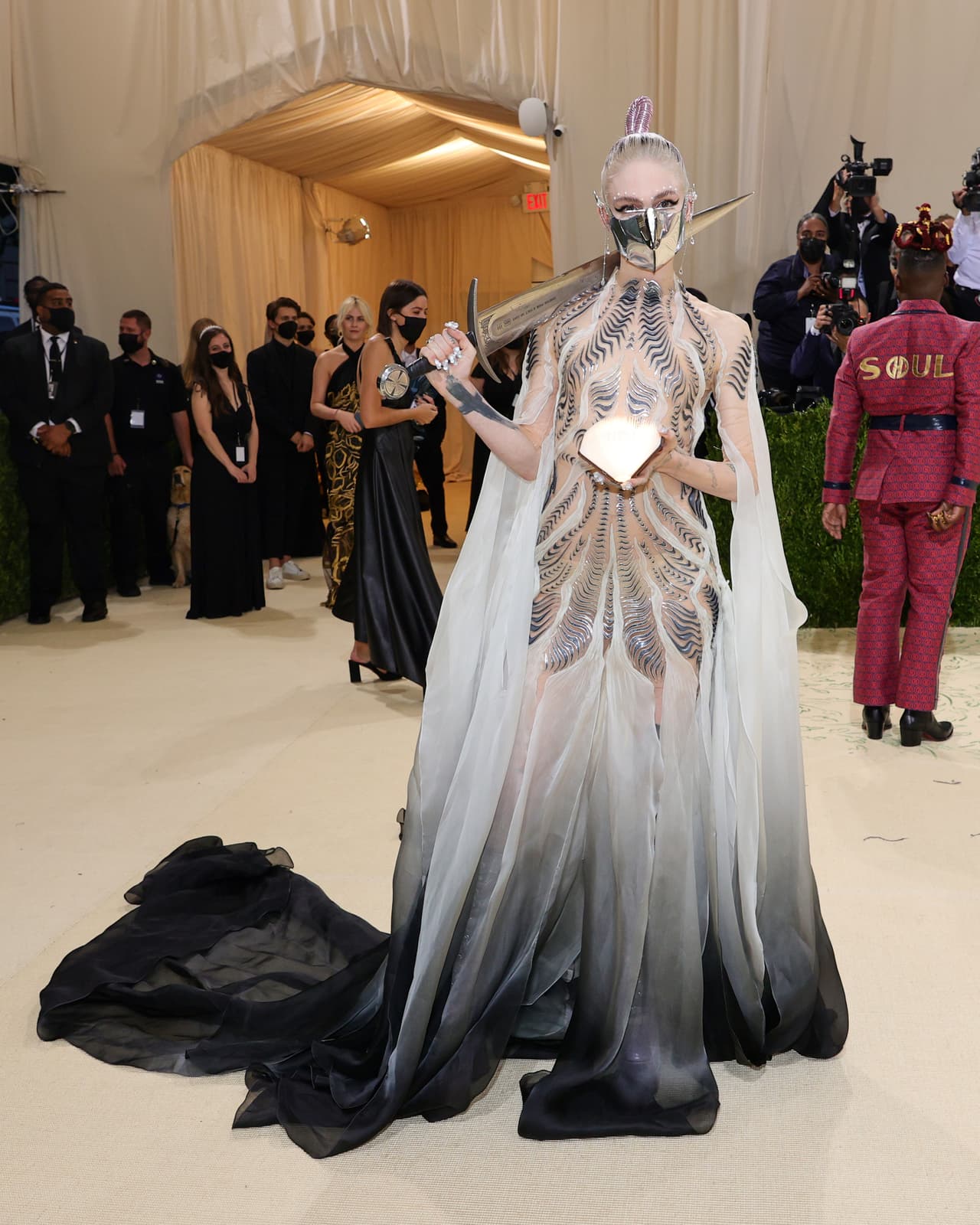 <b>Grimes</b> dio de qué hablar por su aspecto futurista en un modelo de Iris Van Herper. Su espada y la mascarilla plateada fueron algunos de los accesorios más notorios de la alfombra.