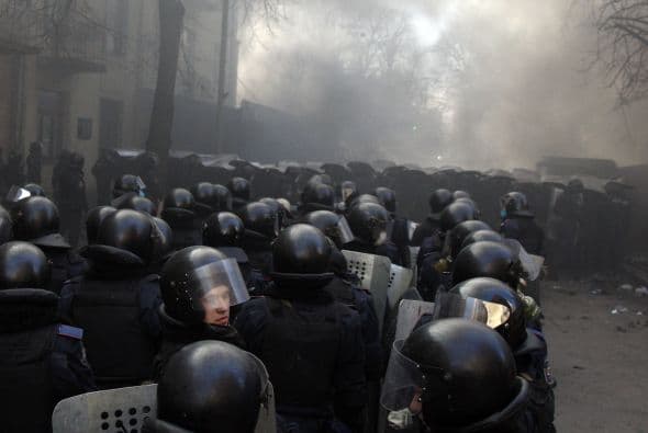 La policía ucraniana cercó hoy a los manifestantes en el corazón de las protestas opositoras de la plaza de la Independencia de Kiev (Maidán), tras una jornada en la que murieron 14 personas en los disturbios que estallaron en la capital. Víktor "Yanukóvich se ha convertido en un presidente sangriento", aseguró hoy el dirigente opositor Vitali Klitschkó en un llamamiento a los países democráticos para que intervengan en Ucrania y frenen la violenta confrontación. Según se acercaba la medianoche, los temidos Berkut, el destacamento antidisturbios, estrechaban el cerco en torno a los miles de manifestantes concentrados en el Euromaidán, bastión de las protestas desde el pasado 21 de noviembre. "Los extremistas de la oposición han cruzado la línea roja; matan a inocentes en la calles de la capital de Ucrania, vejan a mujeres, queman edificios y automóviles. Y si los disturbios continúan, nos veremos obligados a actuar con firmeza", rezaba el ultimátum del Servicio de Seguridad y el Ministerio del Interior de Ucrania. Advierten a los americanos que se queden dentro de las casas y de nuevo se sienten explosiones en la ciudad.