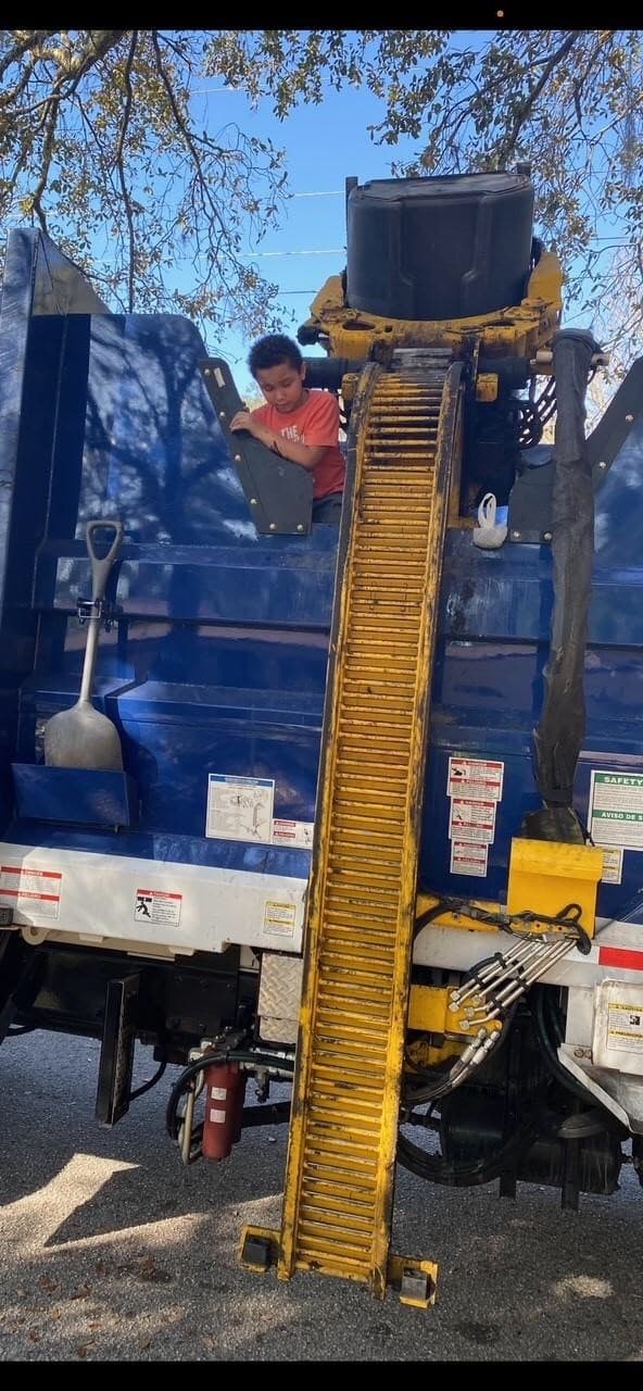 Después de ser rescatado del camión de la basura, Elías Quezada, de 7 años, observa con seguridad cómo se recolecta la basura.