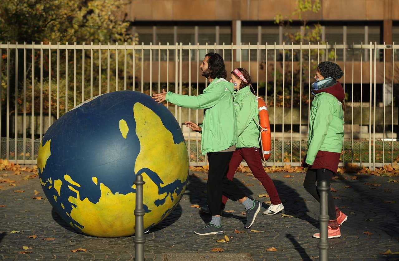 Varios jóvenes ruedan un planeta de goma hacia las manifestaciones contra la quema de combustibles fósiles que se organizaron en las vísperas de la COP23.