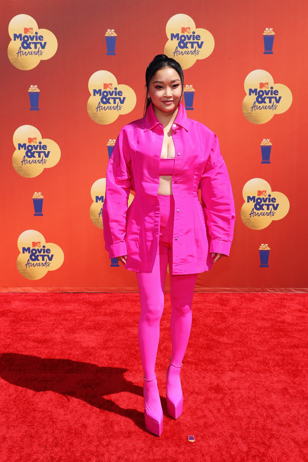 <b>Lana Condor</b>, actriz y youtuber vietnamita, apostó por el atuendo completo en fucsia de Valentino. Su 'outfit' incluía gabardina, top, leggins y plataformas con correa en el tobillo, todo en un vibrante rosa.