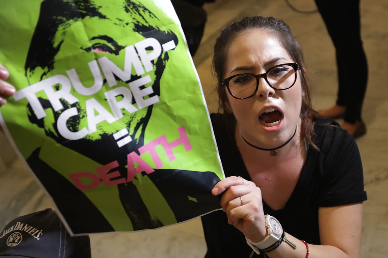 “Trumpcare equivale a muerte”, se lee en el cartel que llevaron muchos de los manifestantes como esta joven que se sentó en la puerta de la oficina del senador de Arizona, Jeff Flake.