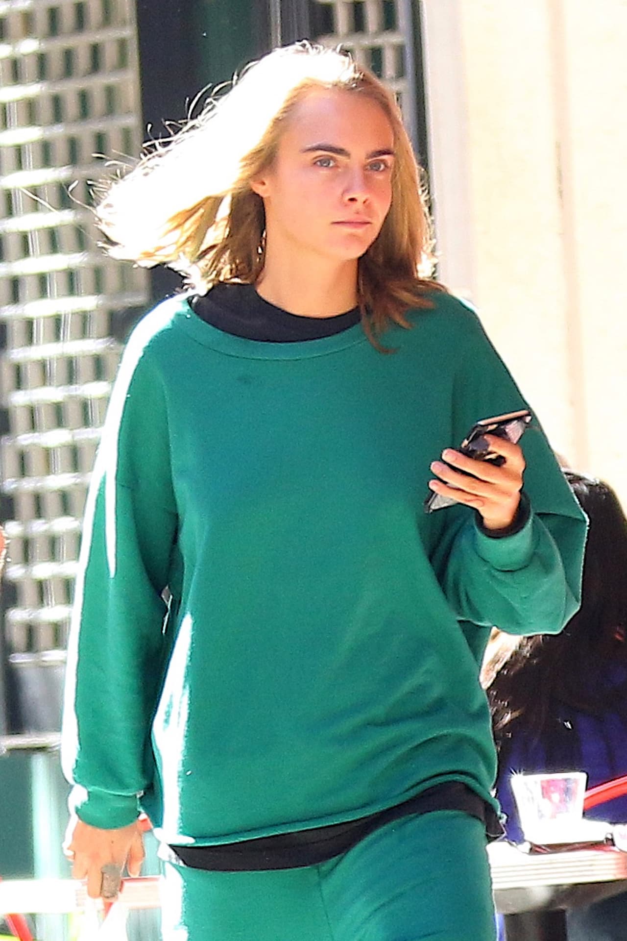 Con el rostro lavado y unos pants verdes.