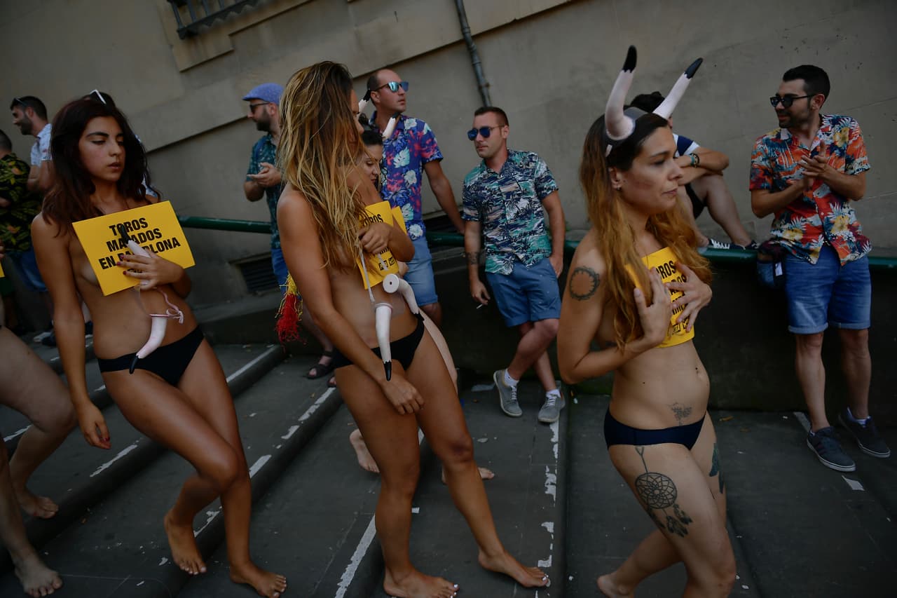 Varias mujeres caminan hacia la protesta en Pamplona, al norte de España, donde la recreación con los toros forma parte de su cultura.