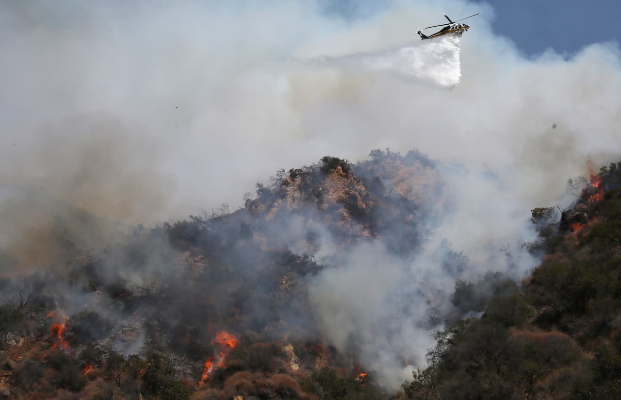 Los bomberos emplearon helicópteros y aviones para rociar la zona del incendio, mientras los efectivos intentaban controlar las llamas desde la montaña.
